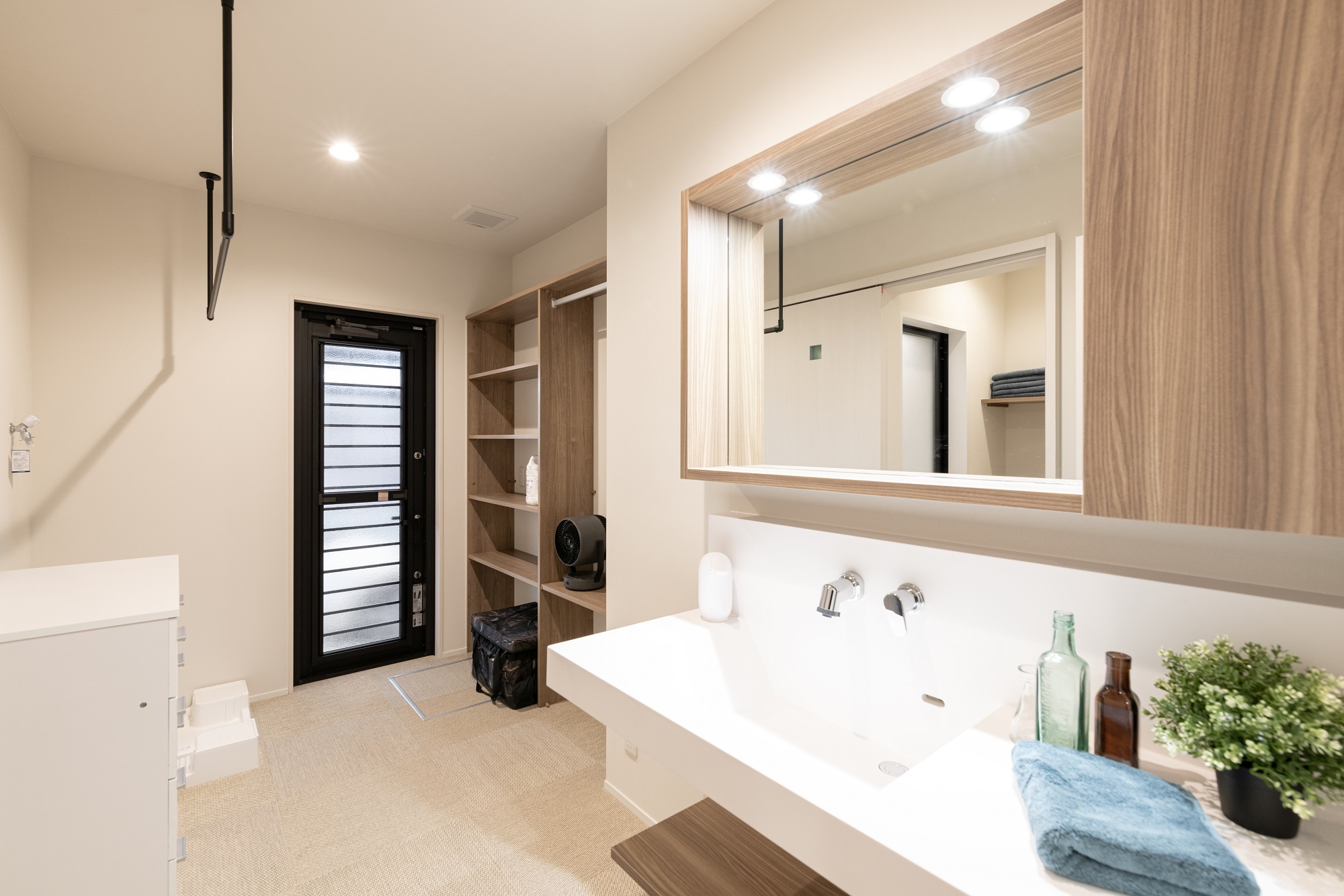 洗面＆ランドリースペース 洗濯機の上に物干し竿を設置。 洗濯、干す、しまうが一部屋で完結できるようにしました。 勝手口は駐車場に繋がっており、カーポートのおかげで雨が降っていても濡れずに出入りができます。